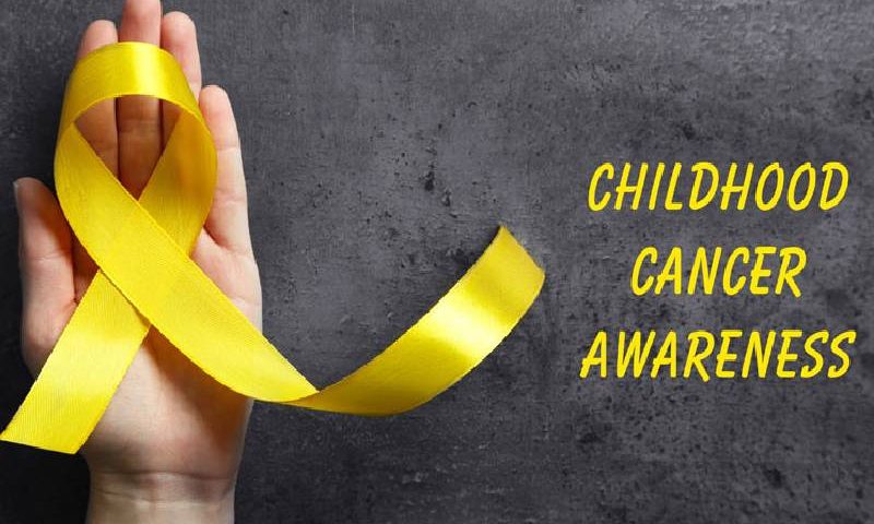 Image That Shows Child hands holding yellow gold ribbon, Childhood cancer Awareness.